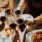 people are eating pizza and drinking wine